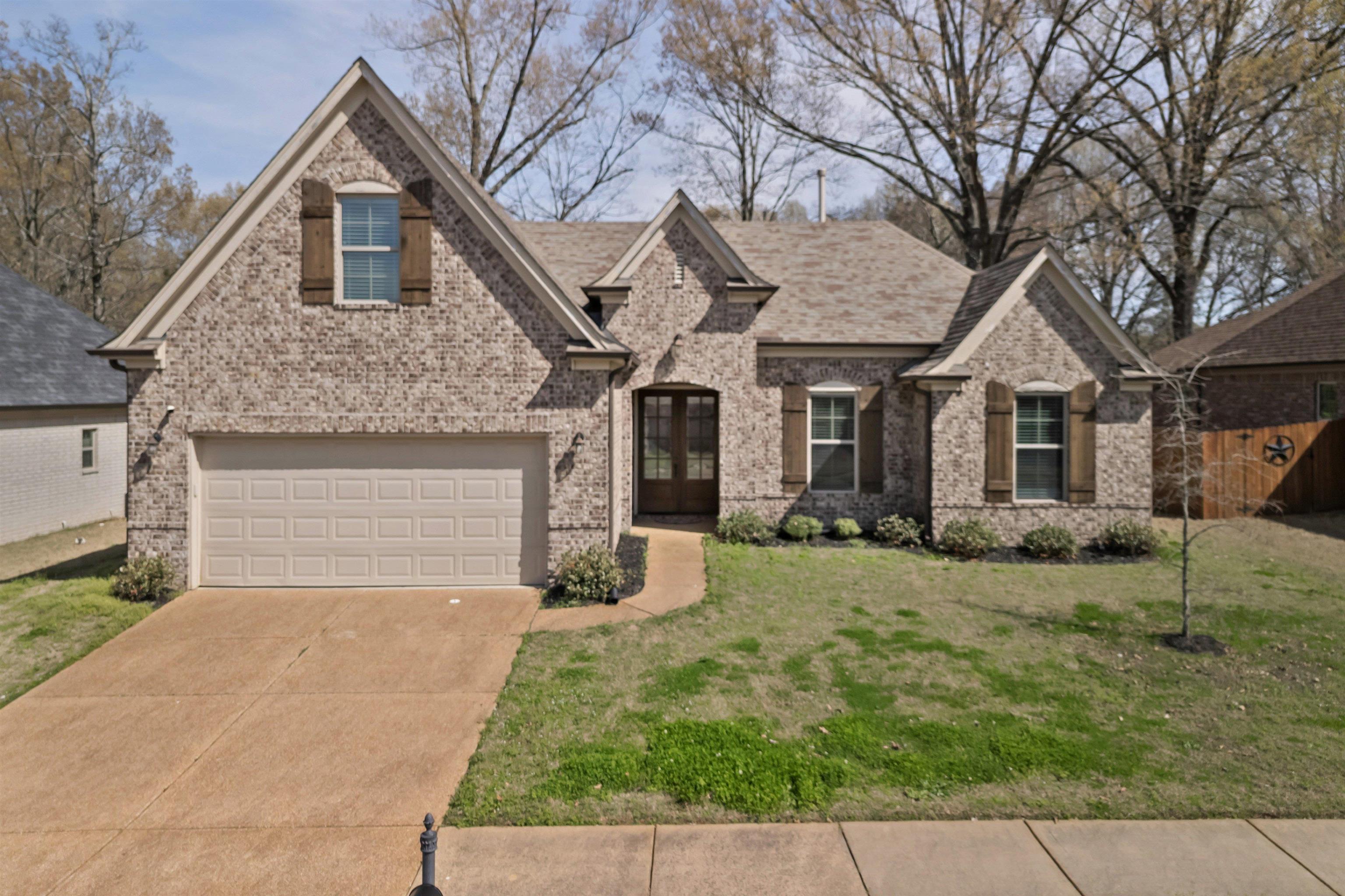4996 Granite Creek Road Memphis, TN 38125 - Photo 31 of 37 a front view of a house with a yard and garage