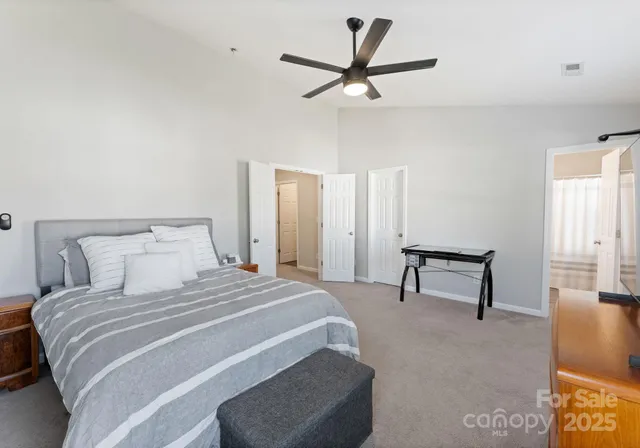 a bedroom with a bed a mirror and a ceiling fan