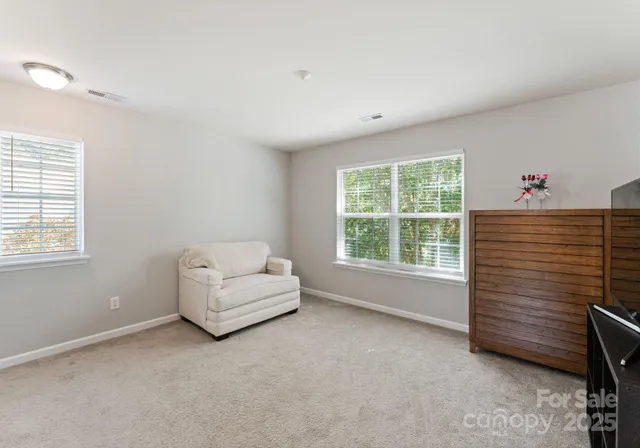 a view of room with windows and white walls