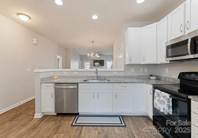 a kitchen with stainless steel appliances granite countertop a stove a sink and a microwave
