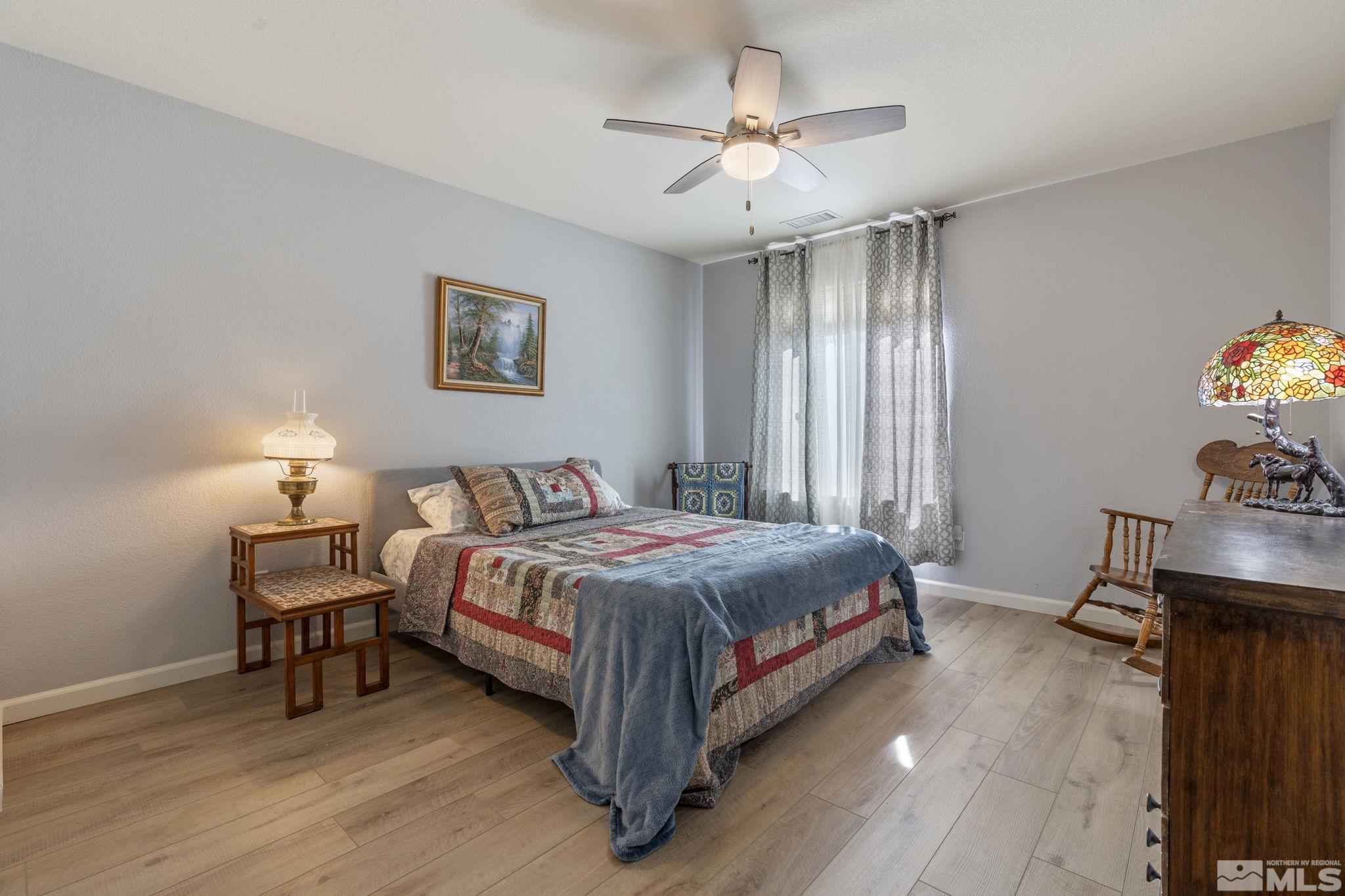 11300 Parma Court Reno, NV 89521 - Photo 31 of 40 a bedroom with a bed and a chandelier