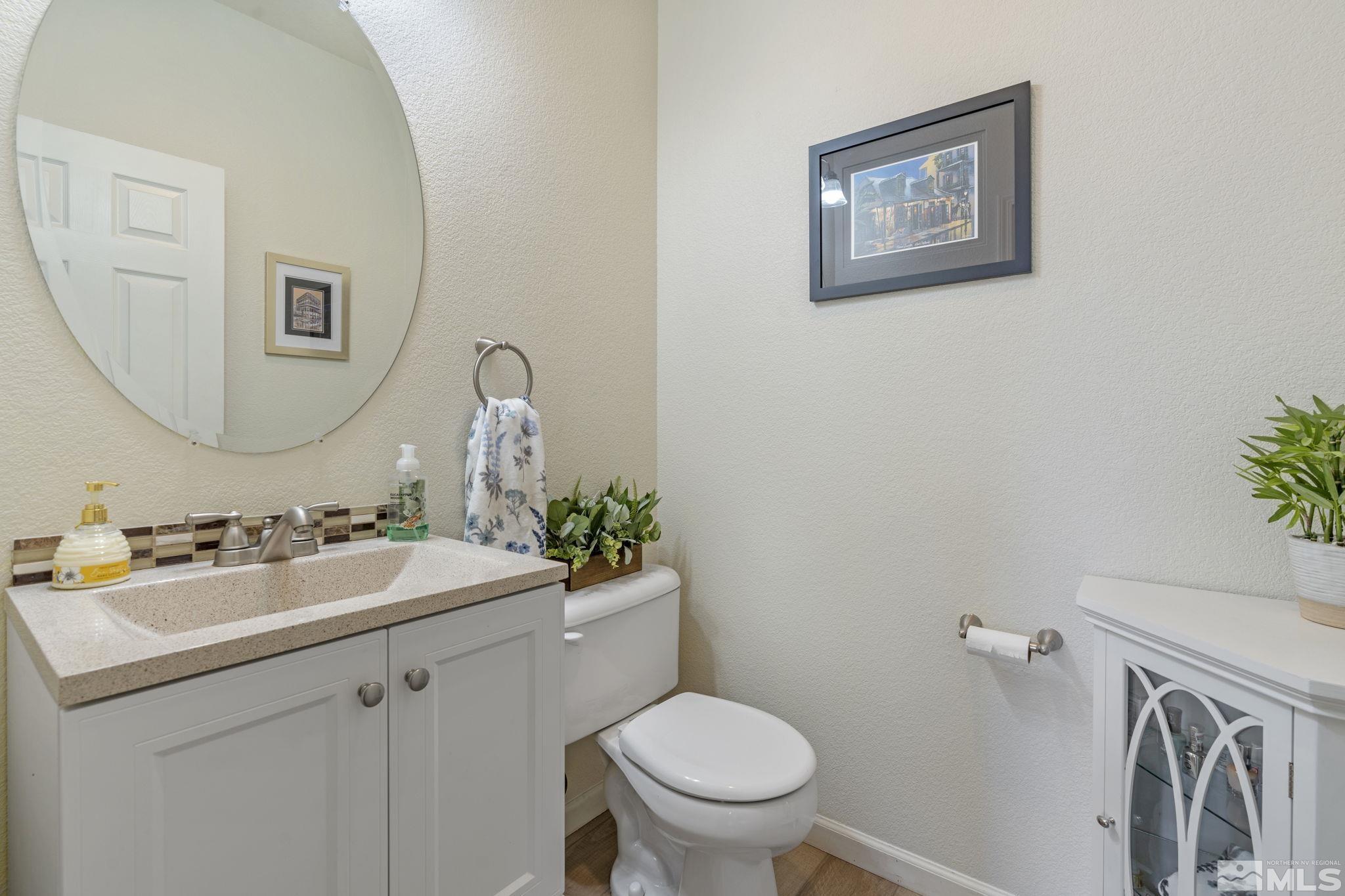 11300 Parma Court Reno, NV 89521 - Photo 35 of 40 a bathroom with a toilet a sink and mirror