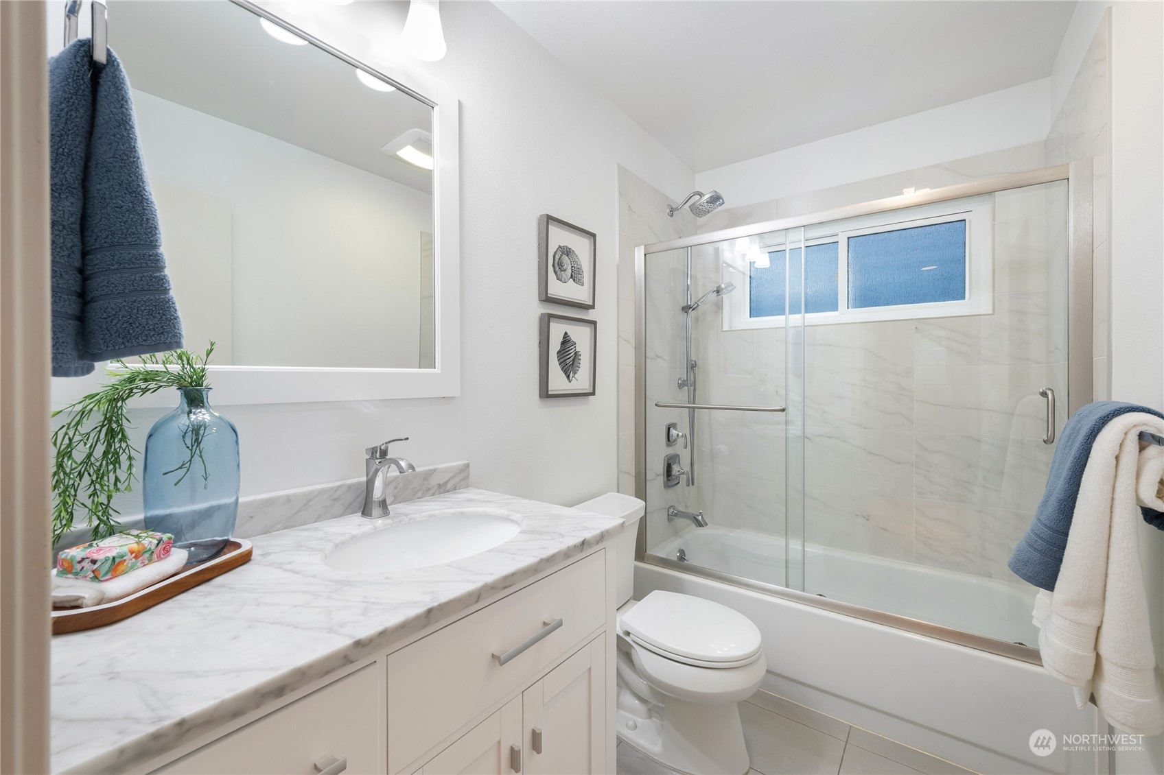 1624 38th Avenue East Seattle, WA 98112 - Photo 23 of 39 a bathroom with a granite countertop sink a toilet a mirror a vanity a shower and bathtub