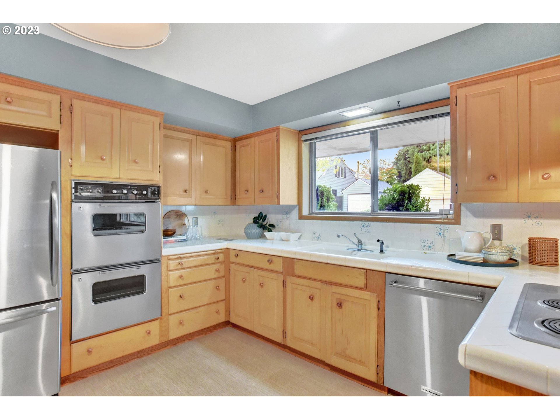6309 Northeast Hancock Street Portland, OR 97213 - Photo 13 of 43 a kitchen with a sink white cabinets and white appliances