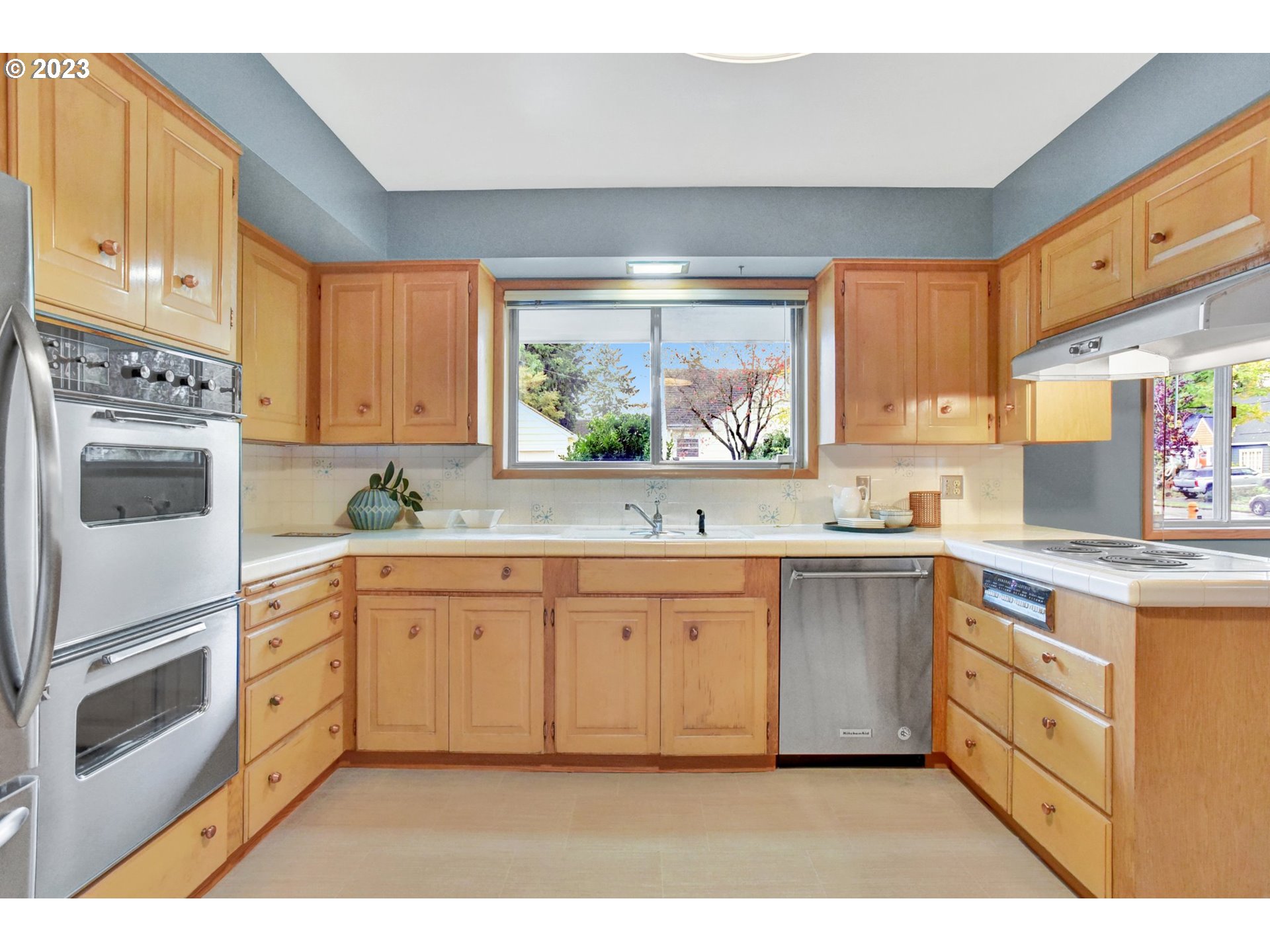 6309 Northeast Hancock Street Portland, OR 97213 - Photo 14 of 43 a kitchen with granite countertop white cabinets and white appliances