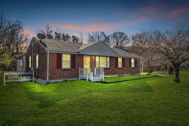 a view of a house with a yard and sitting area