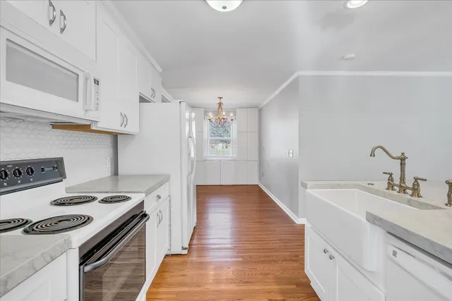 a kitchen with granite countertop a sink stove and cabinets