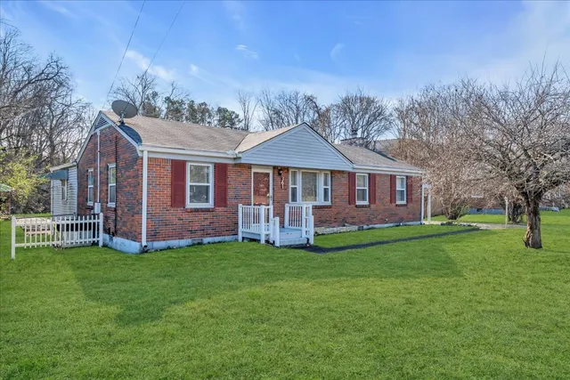 a view of a house with a yard and sitting area