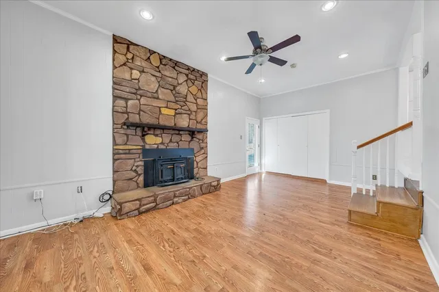 a view of an empty room with a fireplace and a ceiling fan