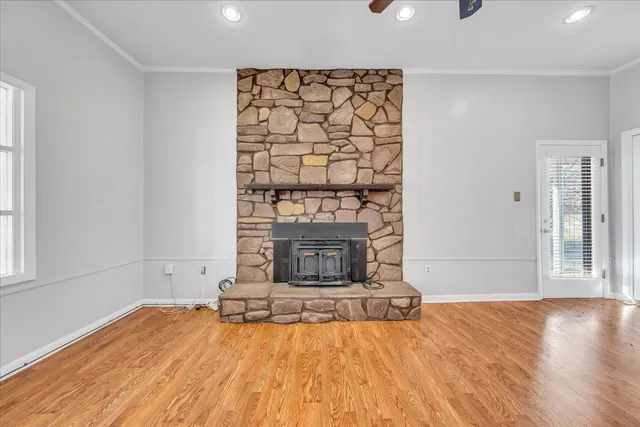 a view of empty room with wooden floor and fireplace