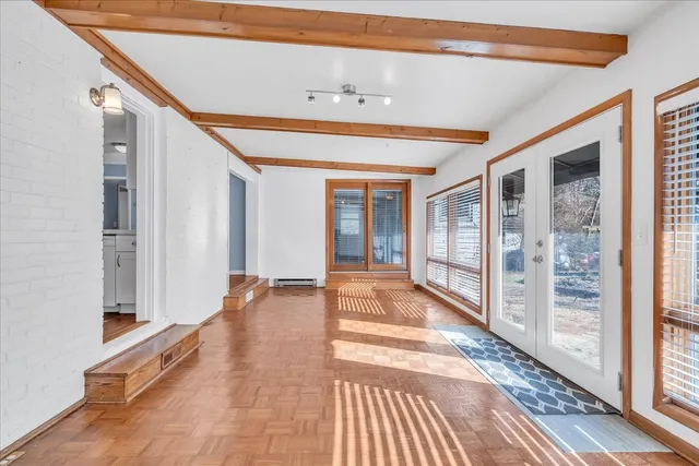 a view of a hallway with wooden floor and windows