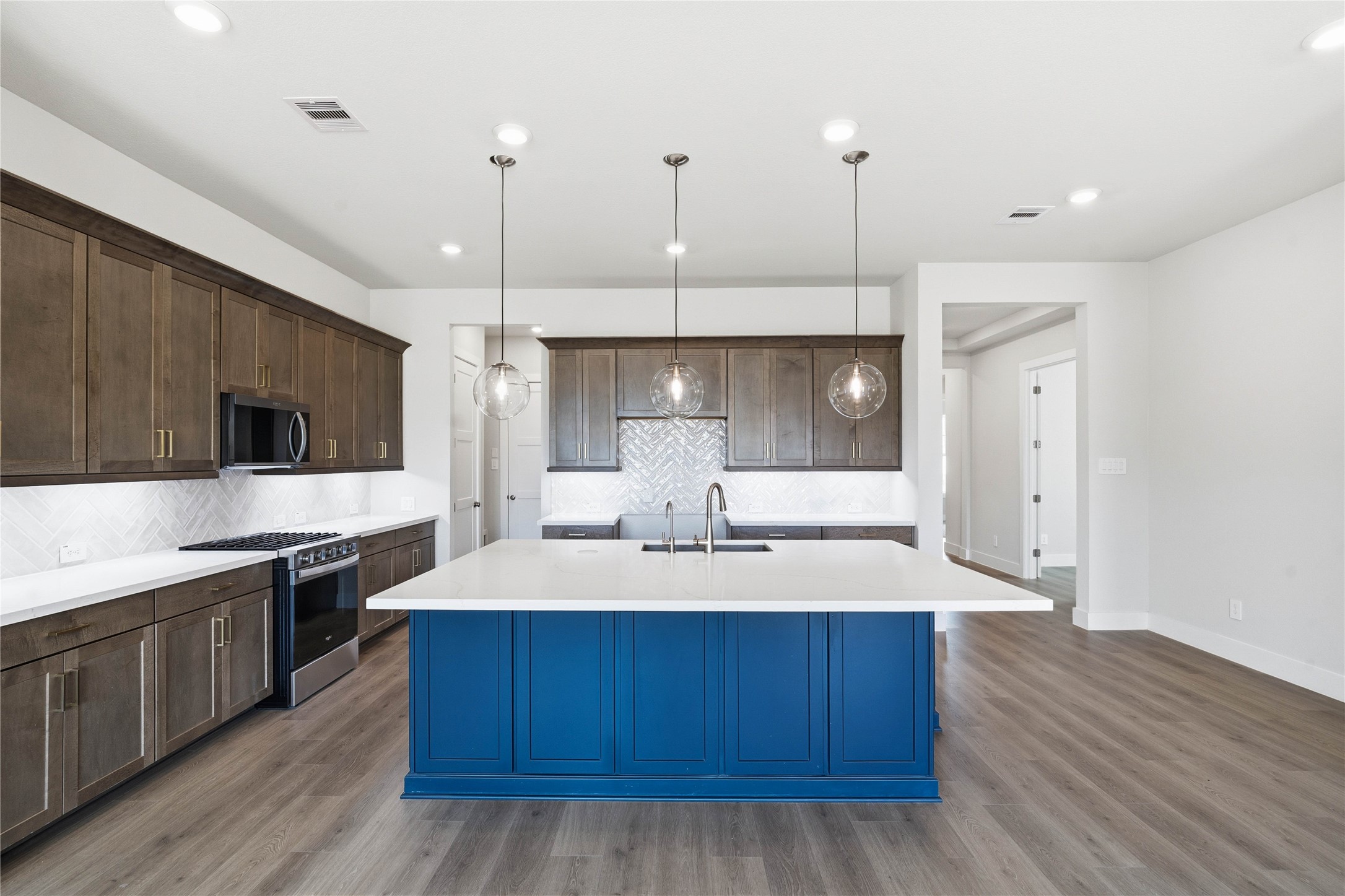9123 Petroglyph Pt Court Porter, TX 77365 - Photo 24 of 43 a kitchen with kitchen island granite countertop wooden cabinets and white appliances