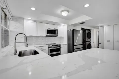 a kitchen with stainless steel appliances a refrigerator sink and stove