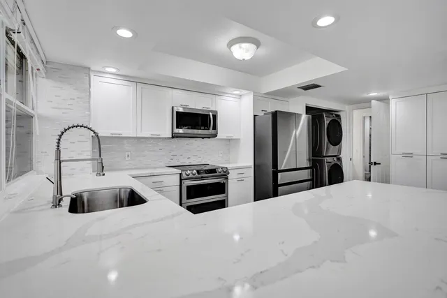 a kitchen with stainless steel appliances a refrigerator sink and stove