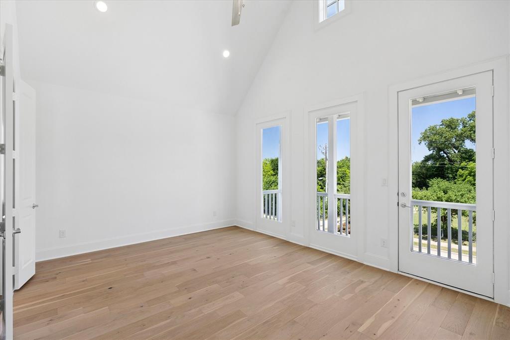 1362 East Crosby Road Carrollton, TX 75006 - Photo 11 of 22 Spacious room featuring vaulted ceilings, recessed lighting, wood-finish flooring, and multiple French doors opening to balconies with white railings