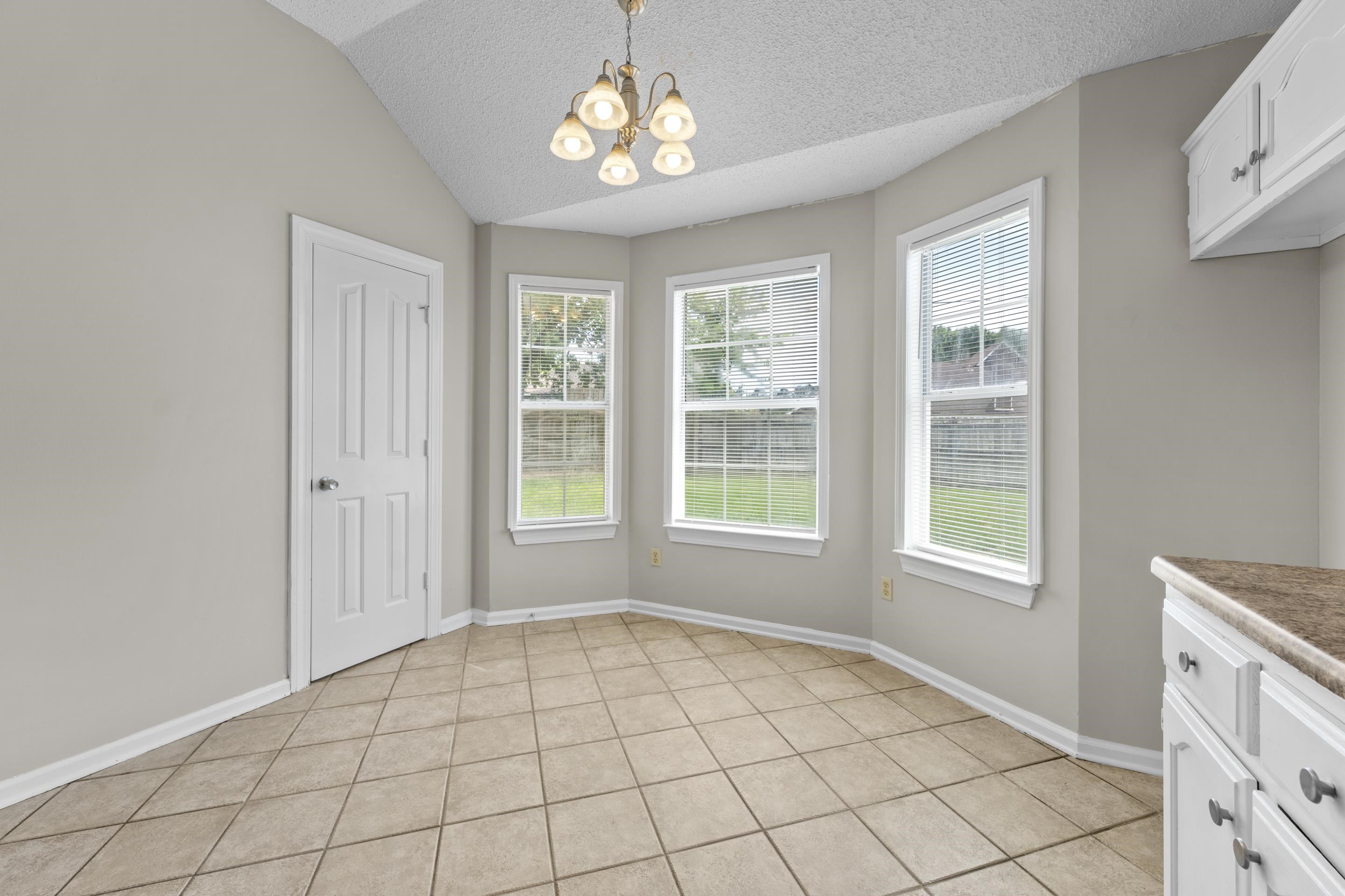 5339 Shady Ridge Cove Memphis, TN 38141 - Photo 13 of 31 Gather around the table in this warm and inviting breakfast nook with vaulted ceilings, oversized windows, and a comfortable layout designed for casual dining and conversation.