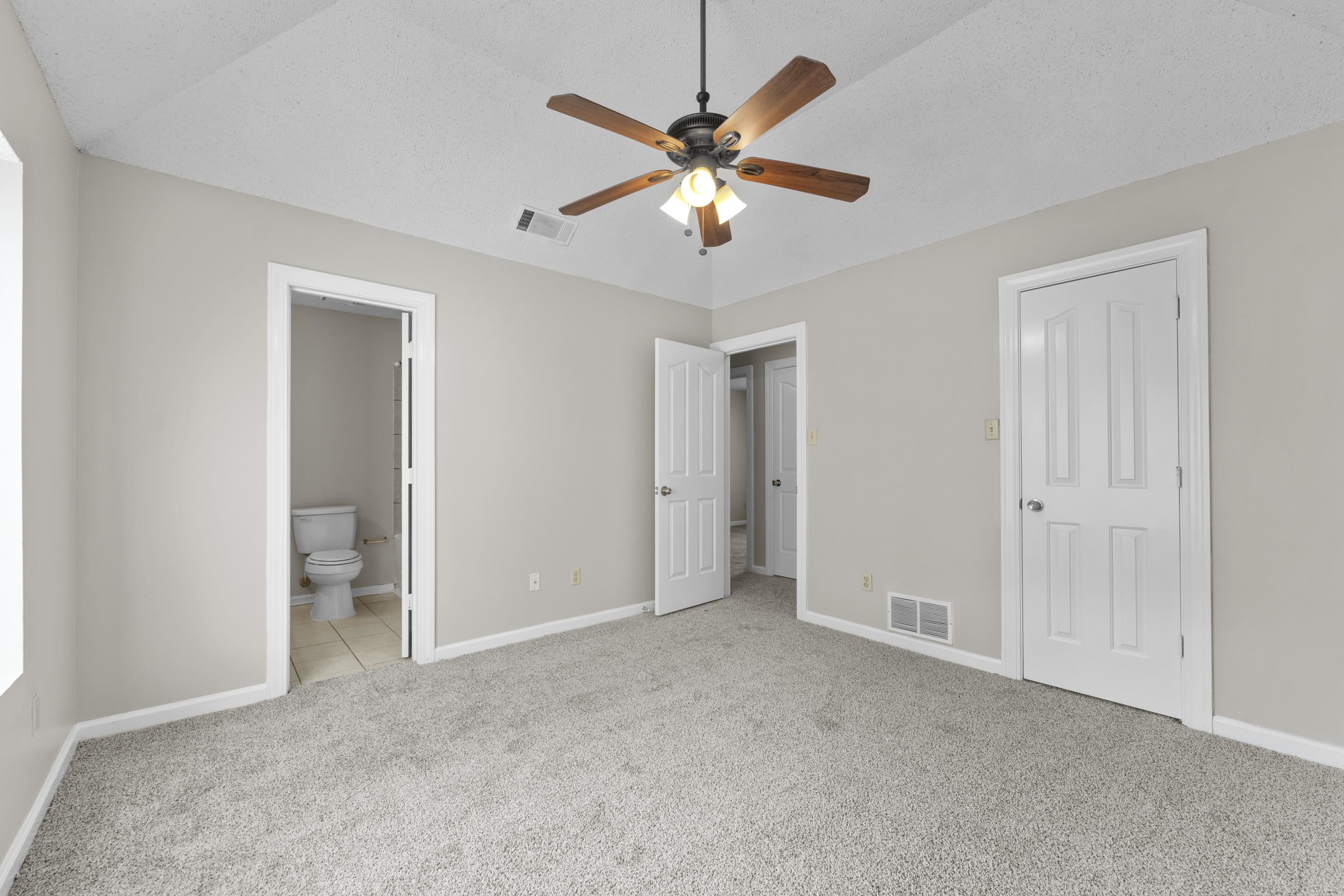 5339 Shady Ridge Cove Memphis, TN 38141 - Photo 16 of 31 Enjoy the comfort of a large primary suite complete with a ceiling fan, fresh neutral tones, and convenient access to the private bathroom and closet space.