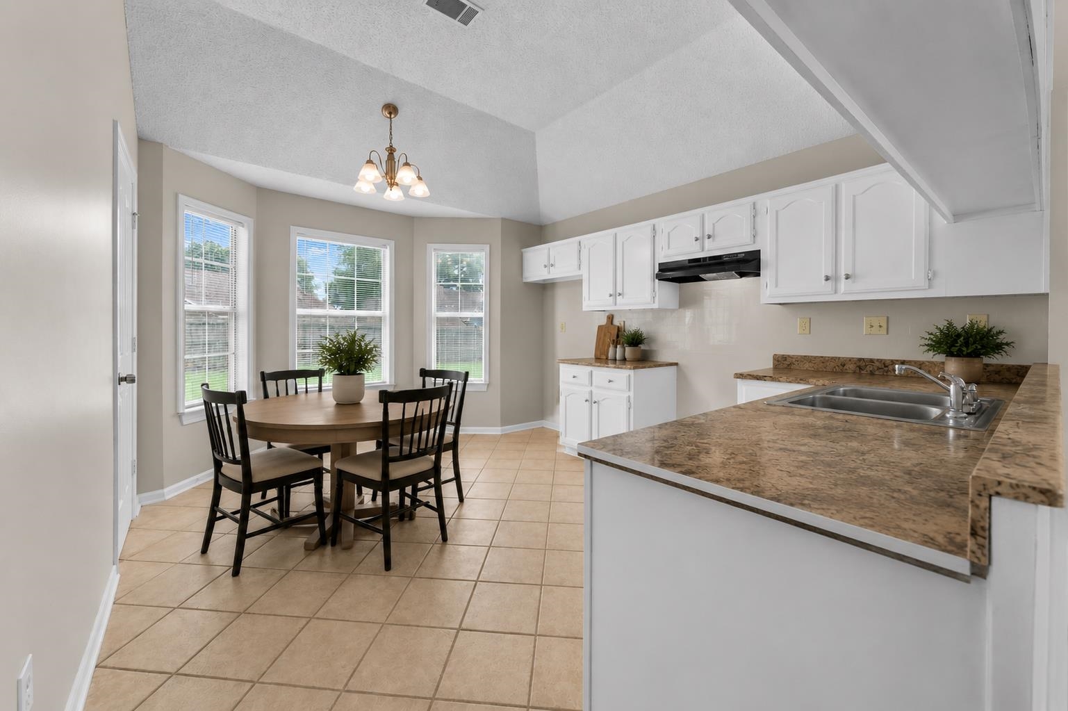 5339 Shady Ridge Cove Memphis, TN 38141 - Photo 8 of 31 The cheerful kitchen features white cabinetry, tile flooring, plenty of counter space, and a cozy breakfast area surrounded by windows overlooking the backyard. A perfect spot to enjoy your morning coffee.