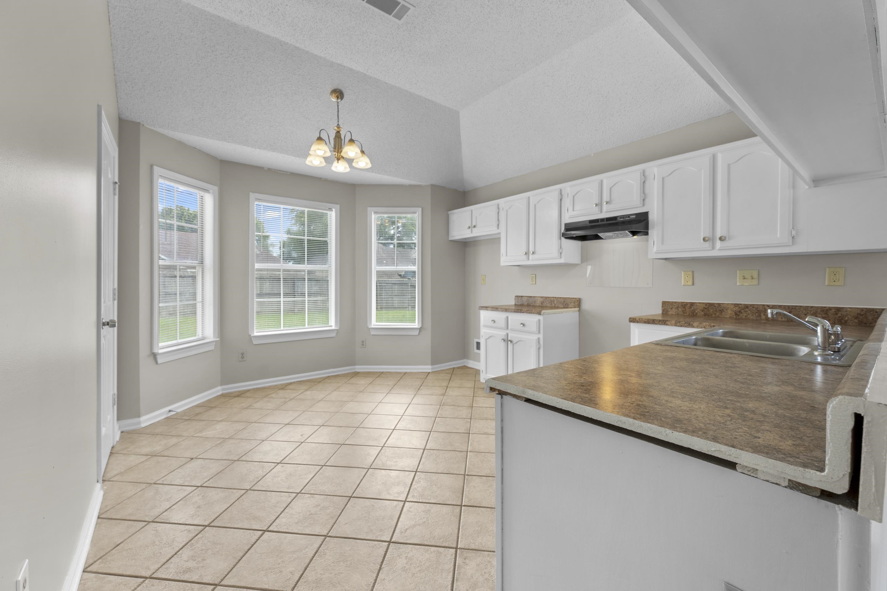 5339 Shady Ridge Cove Memphis, TN 38141 - Photo 9 of 31 Enjoy an open kitchen and breakfast area filled with natural light. The functional layout offers white cabinets, generous workspace, and a bright dining nook ideal for everyday meals.