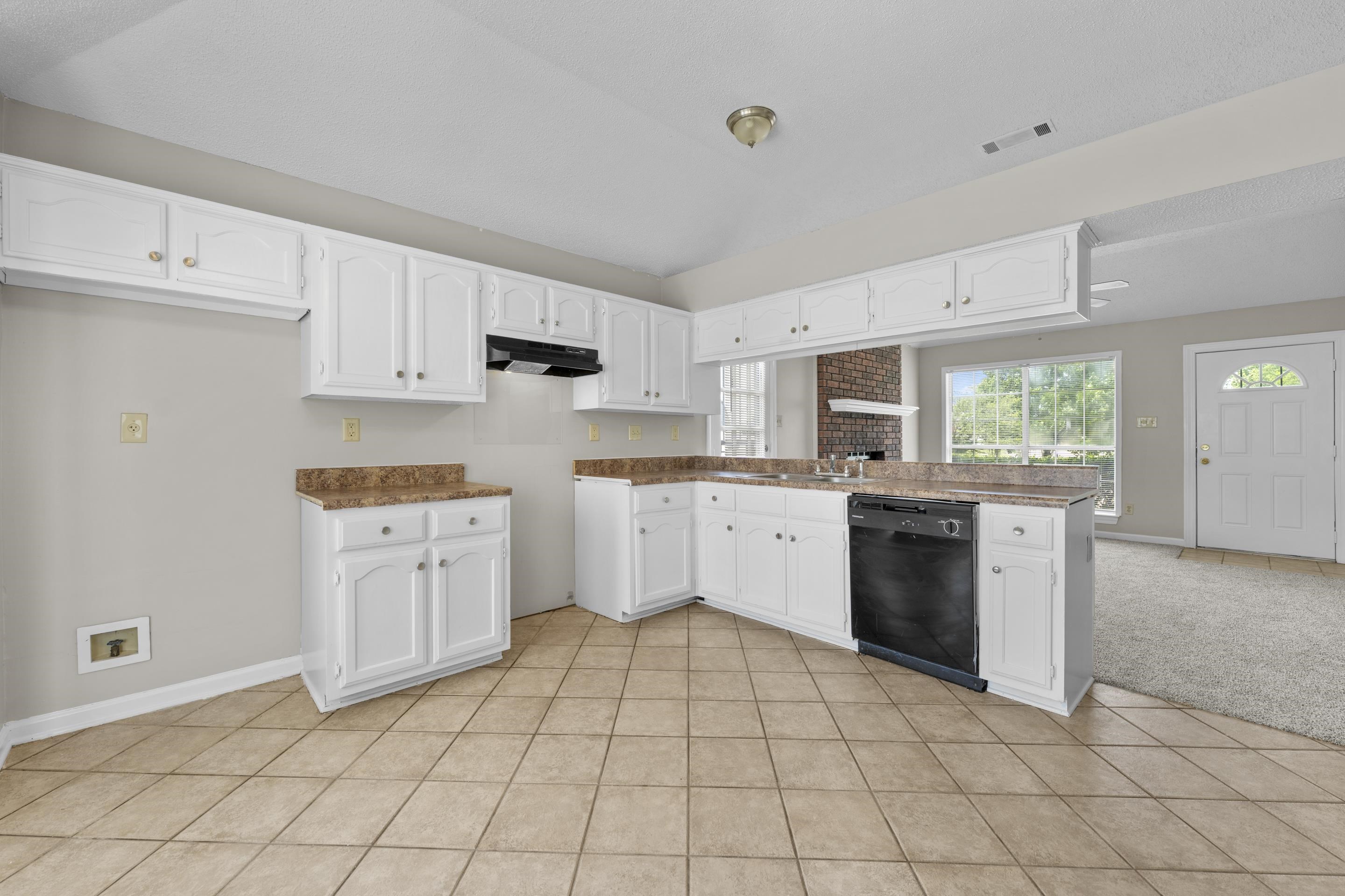 5339 Shady Ridge Cove Memphis, TN 38141 - Photo 10 of 31 This inviting kitchen offers an open-concept design with a breakfast bar, white cabinetry, tile flooring, and easy access to the great room, making entertaining simple and comfortable.