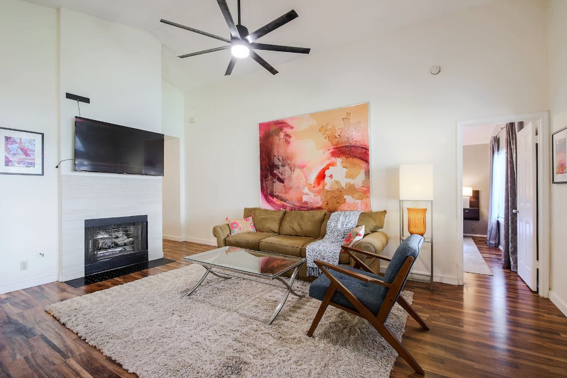 16806 Langland Road Pflugerville, TX 78660 - Photo 12 of 31 a living room with furniture a fireplace and a flat screen tv