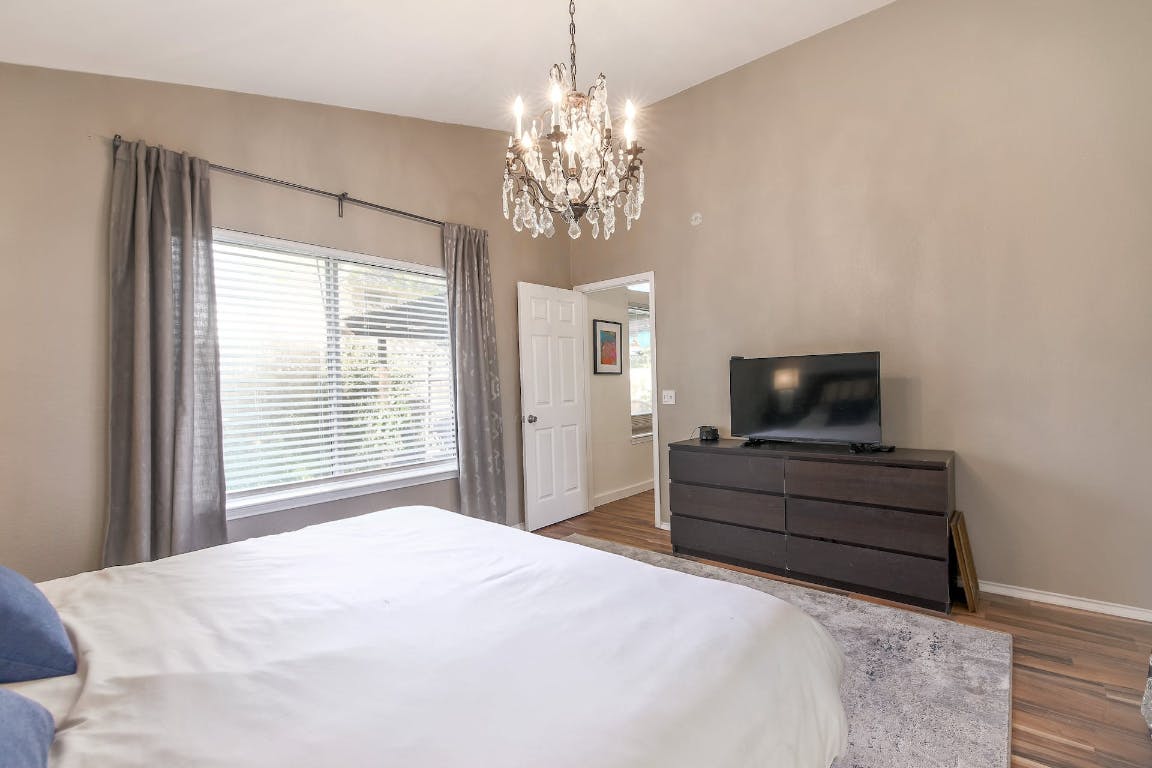 16806 Langland Road Pflugerville, TX 78660 - Photo 19 of 31 a bedroom with a bed and a flat screen tv