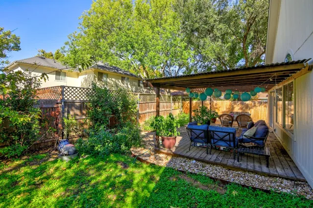 a view of a chair and table in backyard of the house