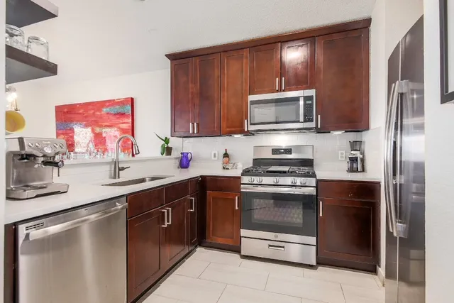 a kitchen with stainless steel appliances granite countertop a stove microwave and sink