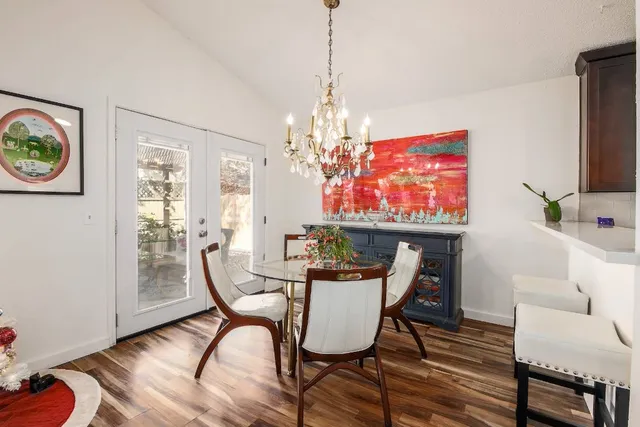 a dining room with furniture a chandelier and wooden floor