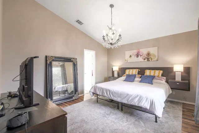 a bedroom with a large bed and a chandelier