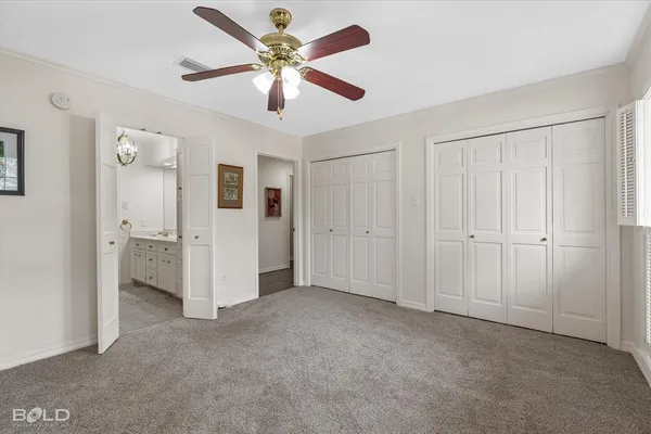 an empty room with closet and a ceiling fan