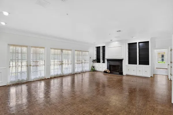 a view of empty room with wooden floor and fireplace