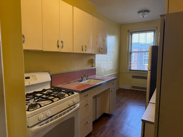 a kitchen with a sink a stove and cabinets