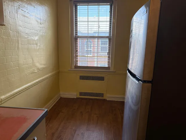 a view of a room with wooden floor and a window