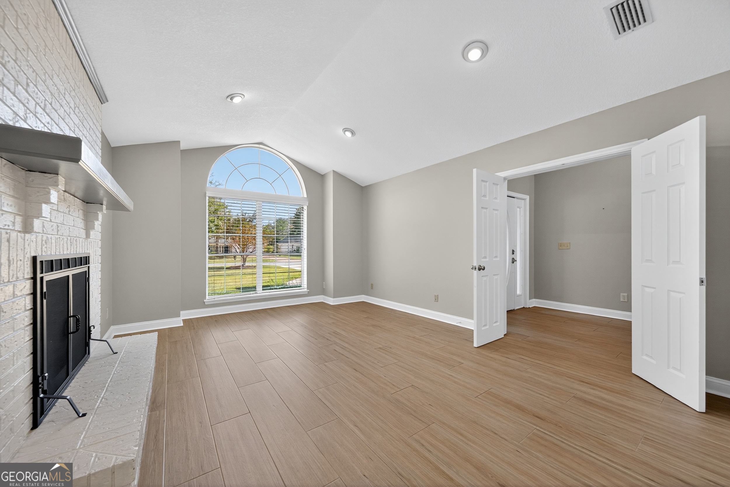 404 Morning Glory Road St. Marys, GA 31558 - Photo 17 of 34 an empty room with wooden floor fireplace and windows
