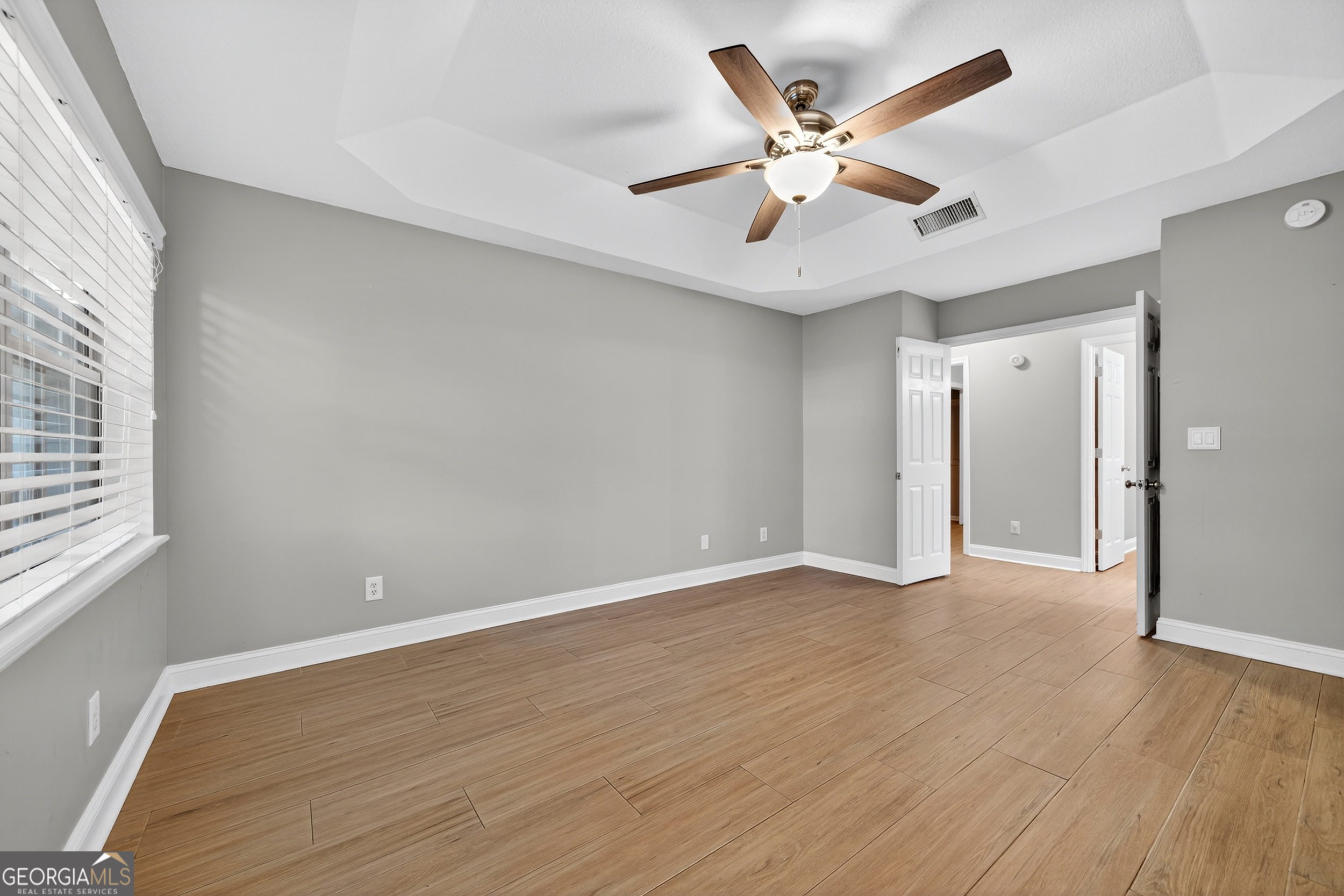 404 Morning Glory Road St. Marys, GA 31558 - Photo 21 of 34 an empty room with wooden floor and ceiling fan