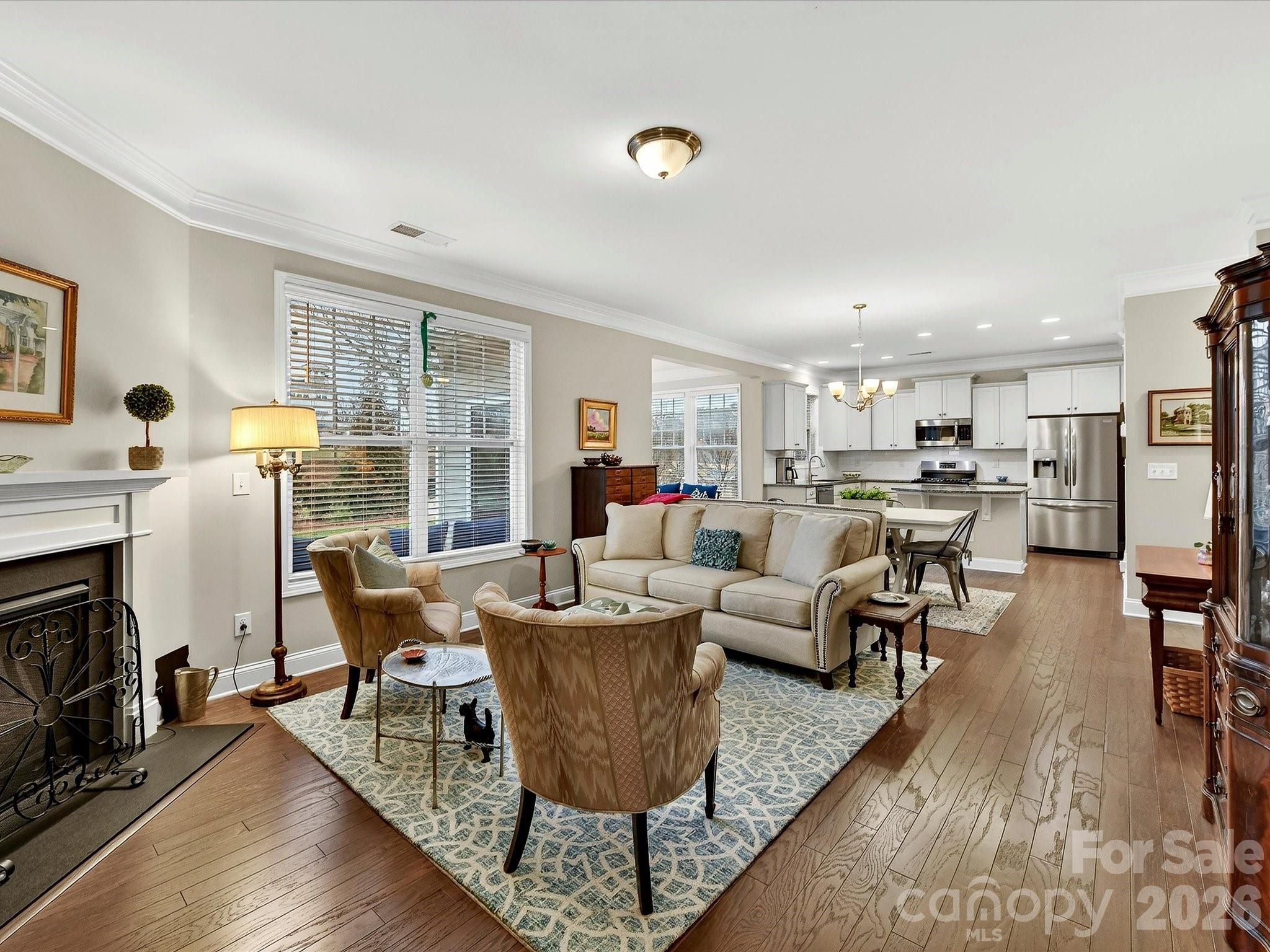 a living room with fireplace furniture and a large window