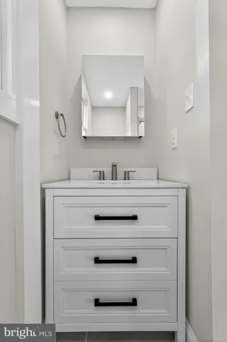 a bathroom with a sink vanity and mirror