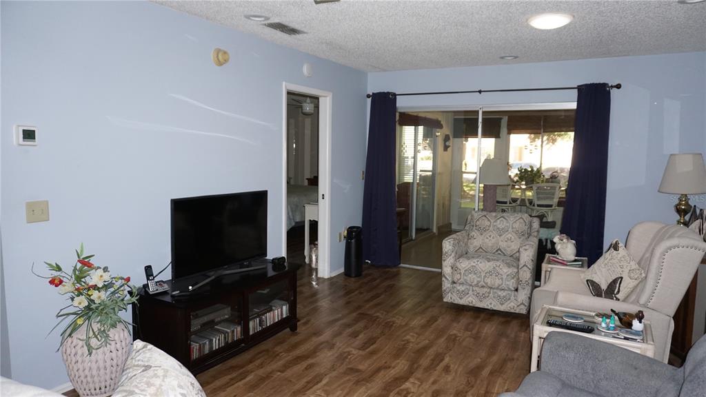 11241 Versailles Lane Port Richey, FL 34668 - Photo 11 of 38 a living room with furniture and a flat screen tv