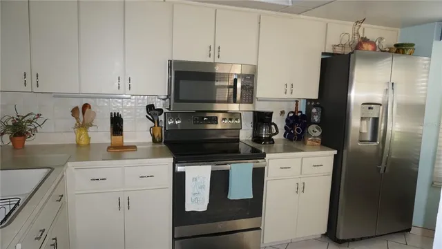 a kitchen with appliances a sink and cabinets