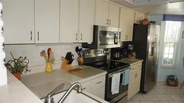 a kitchen with stainless steel appliances granite countertop a sink a stove and a refrigerator