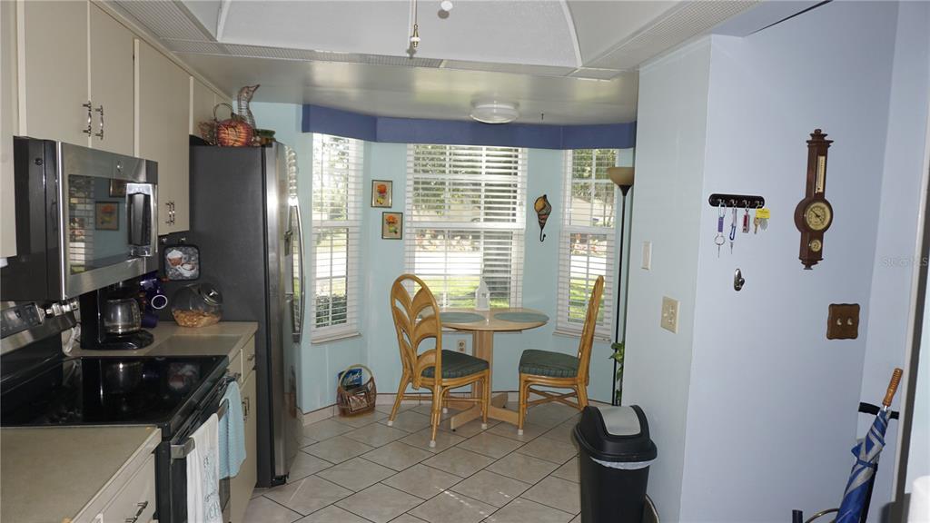 11241 Versailles Lane Port Richey, FL 34668 - Photo 6 of 38 a kitchen with refrigerator and chairs