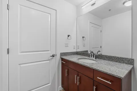 a bathroom with a granite countertop sink and mirror