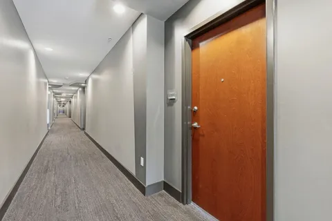 a view of hallway with wooden floor