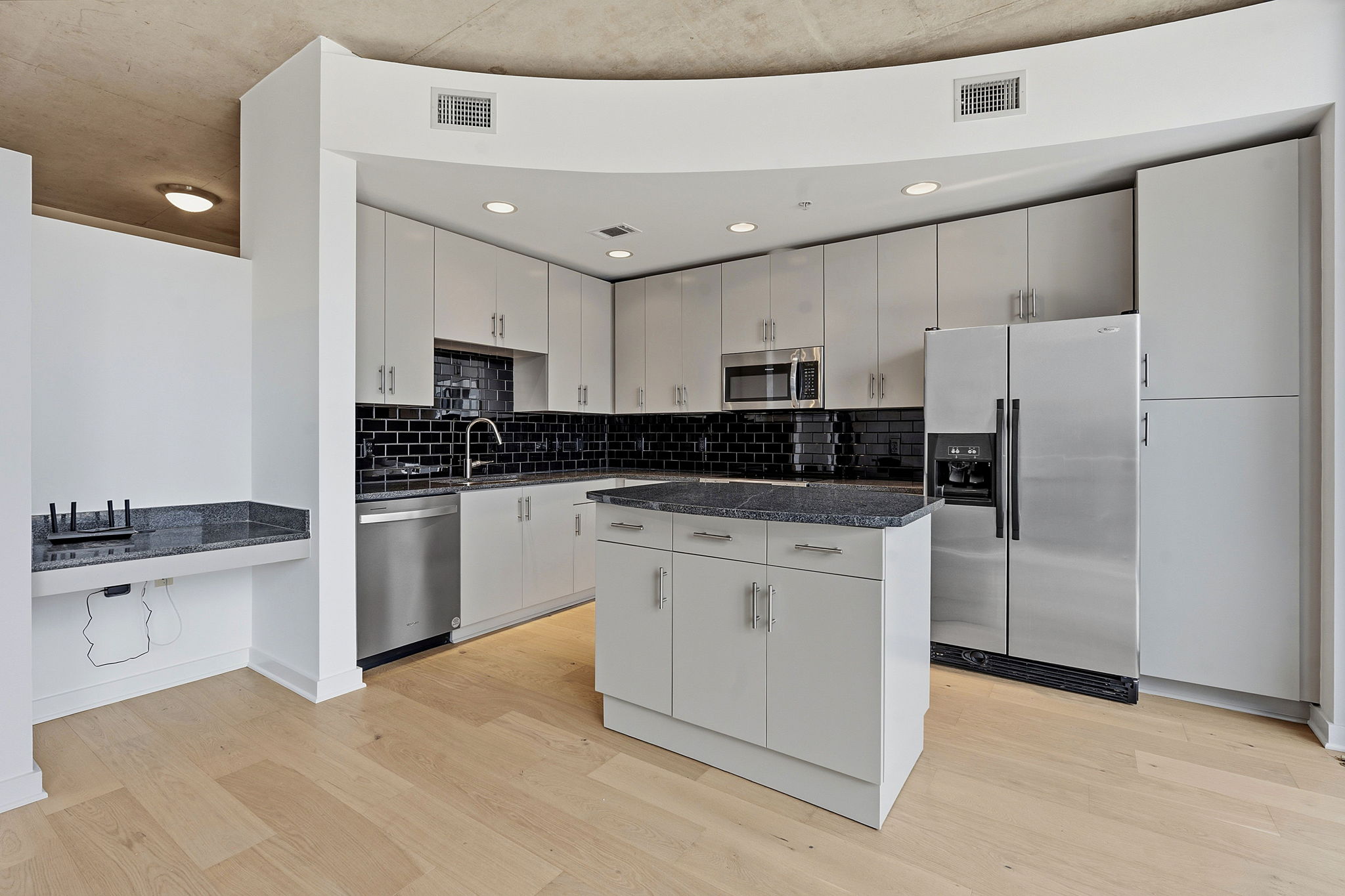 360 Nueces Street, Unit 1303 Austin, TX 78701 - Photo 3 of 40 a kitchen with white cabinets and stainless steel appliances