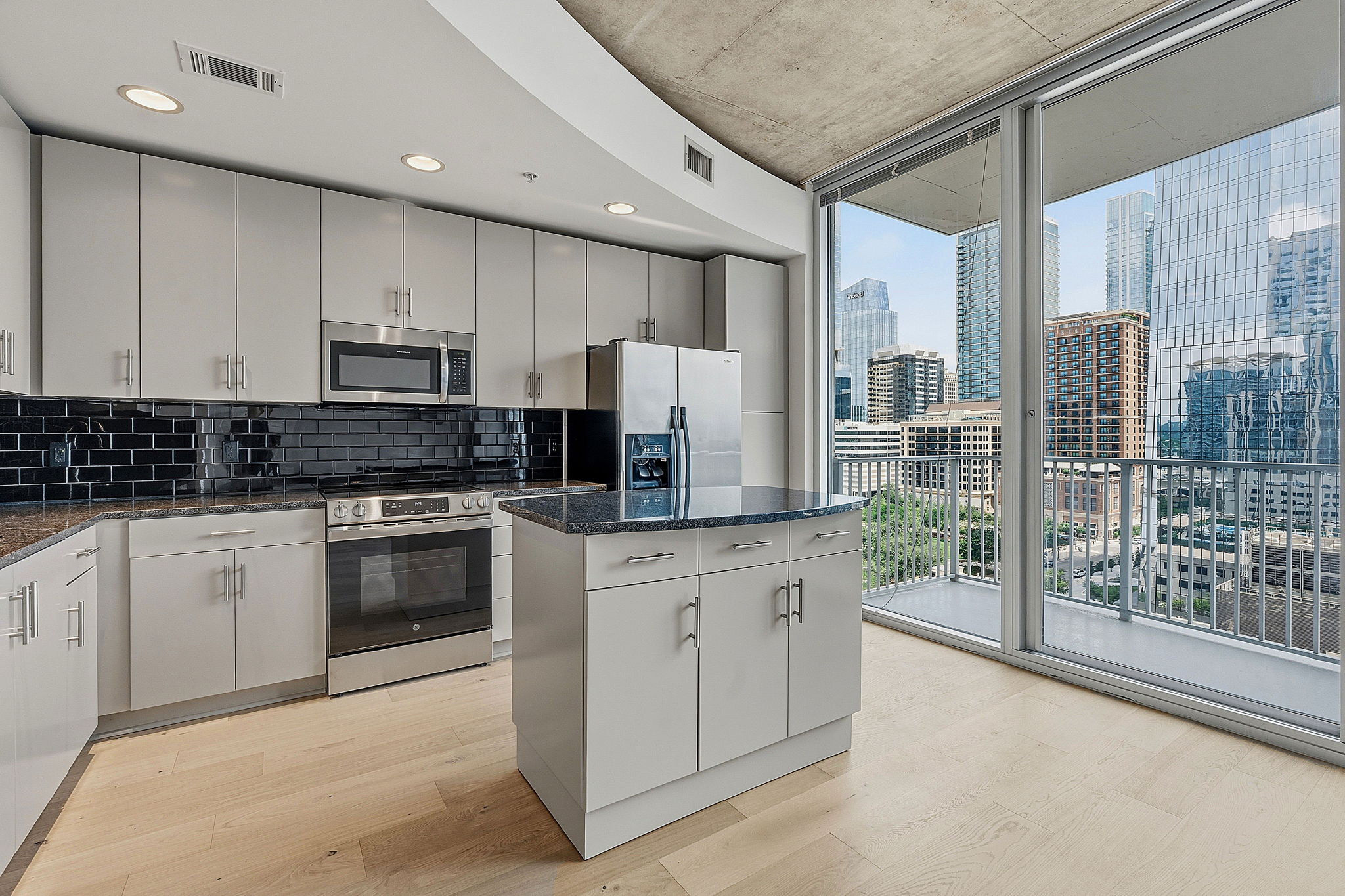360 Nueces Street, Unit 1303 Austin, TX 78701 - Photo 7 of 40 a kitchen with stainless steel appliances granite countertop a stove a sink and a refrigerator