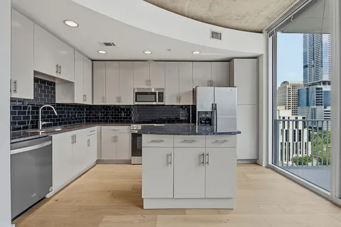 a kitchen with stainless steel appliances granite countertop a stove a sink and a refrigerator