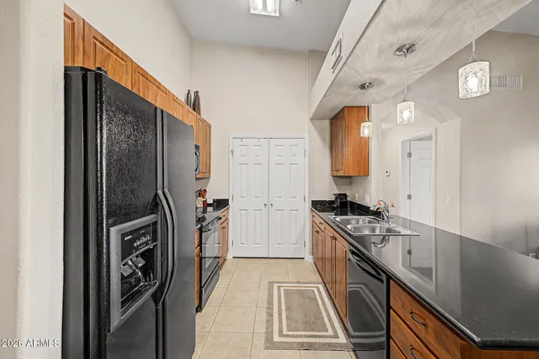 a large dining hall with stainless steel appliances granite countertop a sink dishwasher a dining table and chairs with wooden floor