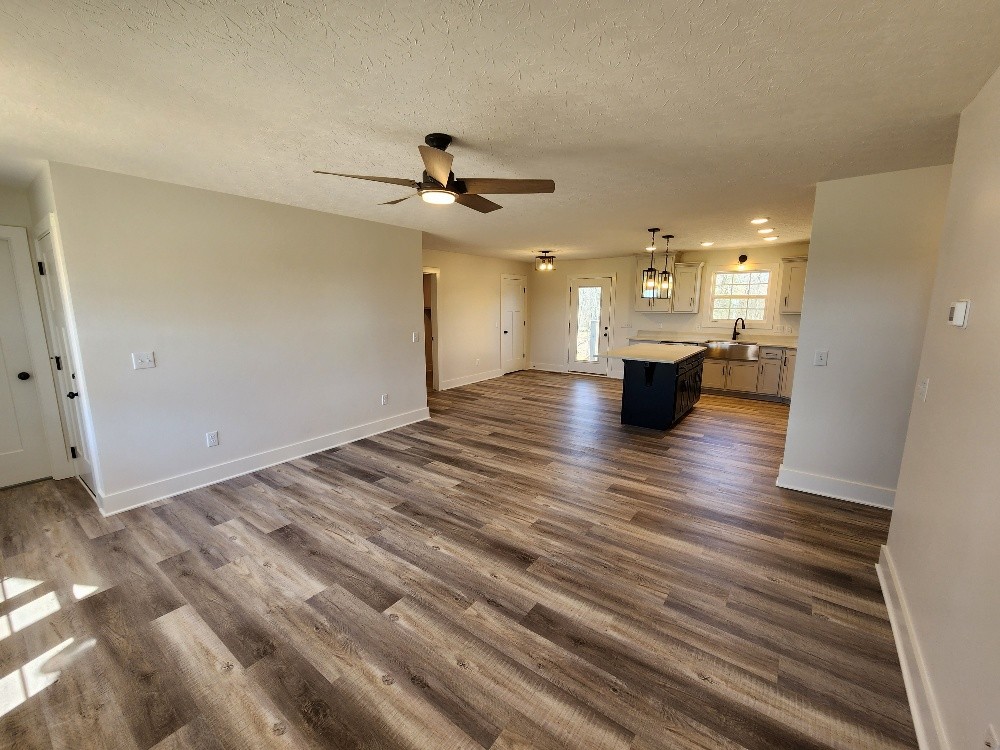 670 Armstrong Road Castalian Springs, TN 37031 - Photo 10 of 25 a view of an empty room and kitchen view with wooden floor