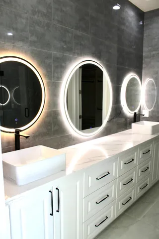 a bathroom with double vanity and a mirror